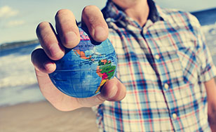 travailler à l'international - image d'une personne qui tient un petit globe terrestre